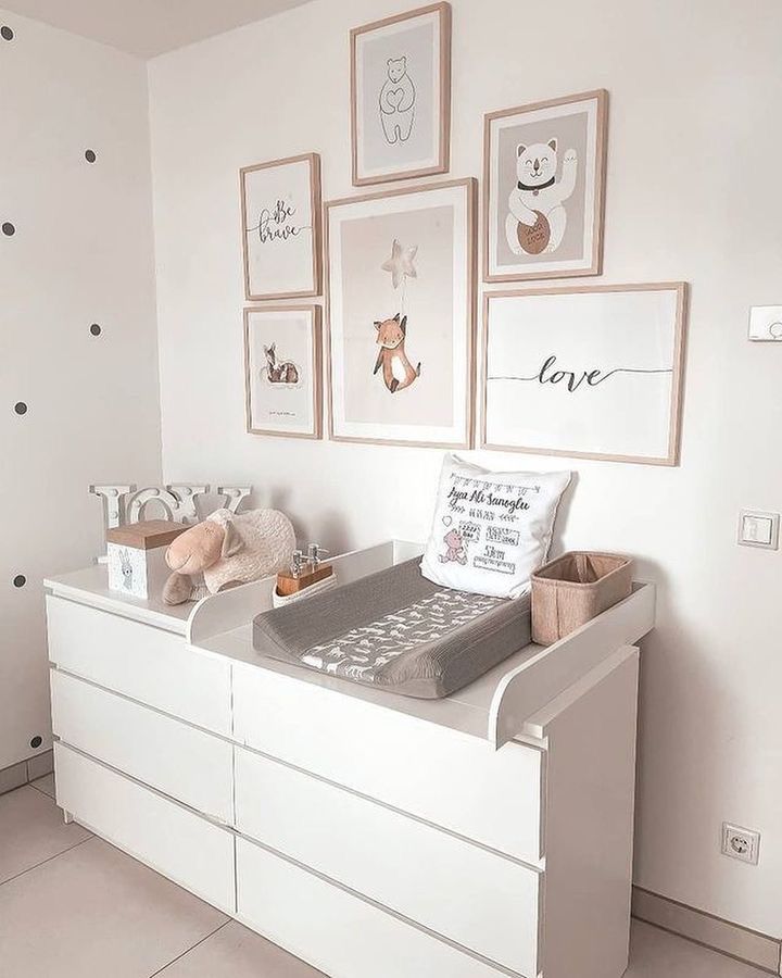 a baby's room with white furniture and pictures on the wall