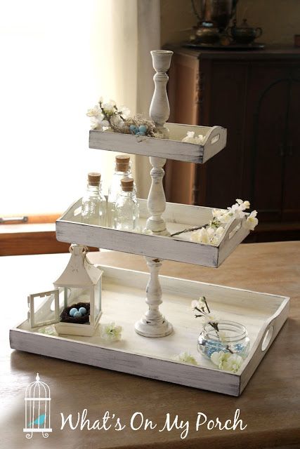 three tiered trays with bottles and flowers in them on top of a table