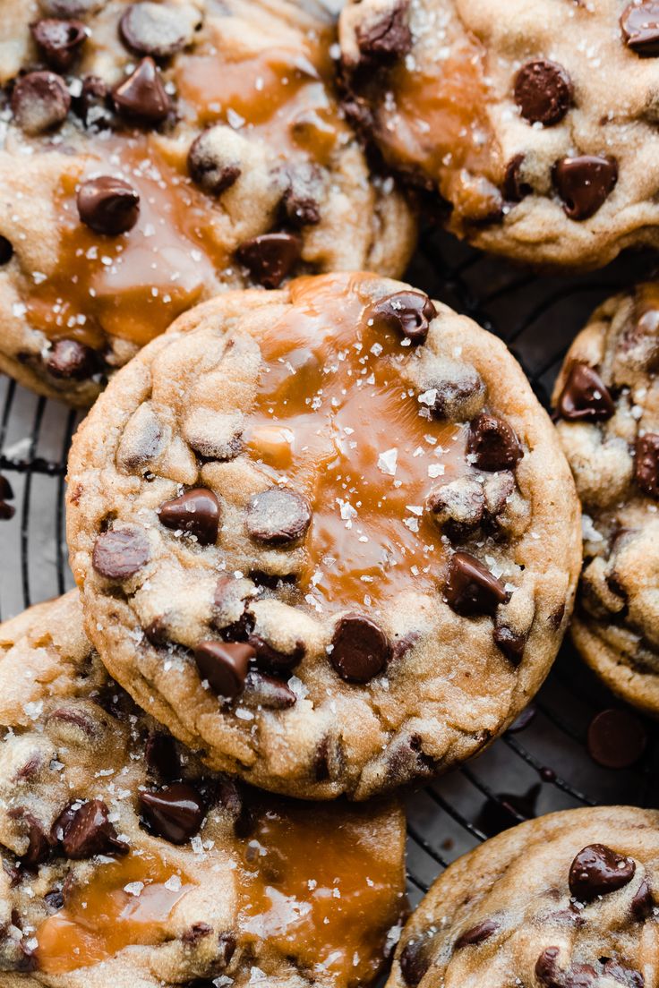 chocolate chip cookies with caramel drizzled on top are cooling on a wire rack