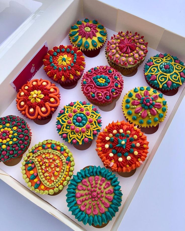 there are many decorated cupcakes in the box