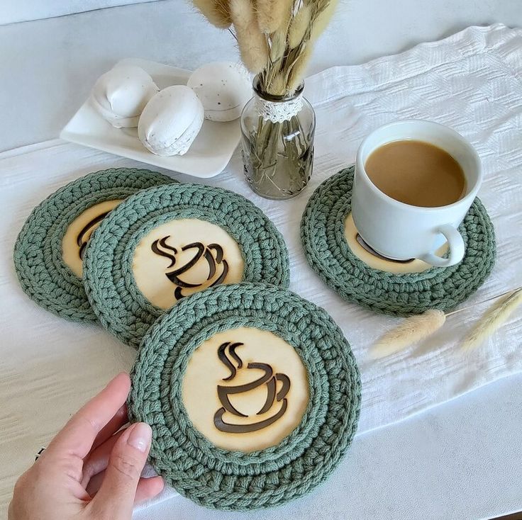 three cookies with coffee on them sitting on a table next to a cup of coffee