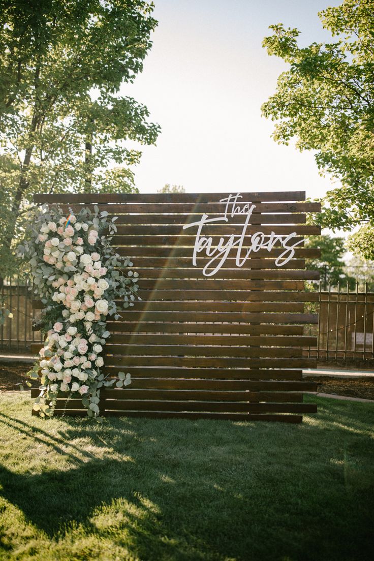 a wooden sign with white flowers on it