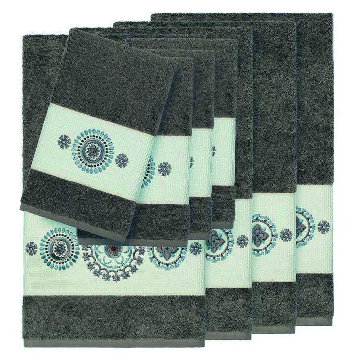 six towels are stacked on top of each other in different colors and patterns, with one folded up to the side