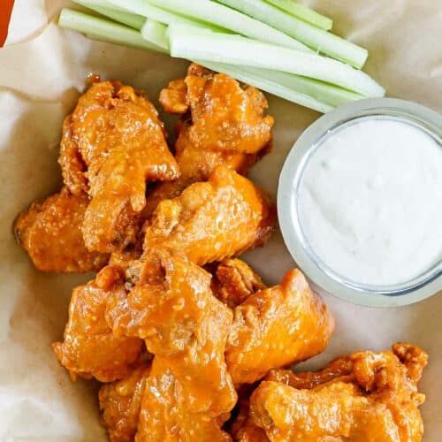 chicken wings and celery with ranch dip on the side, ready to be eaten