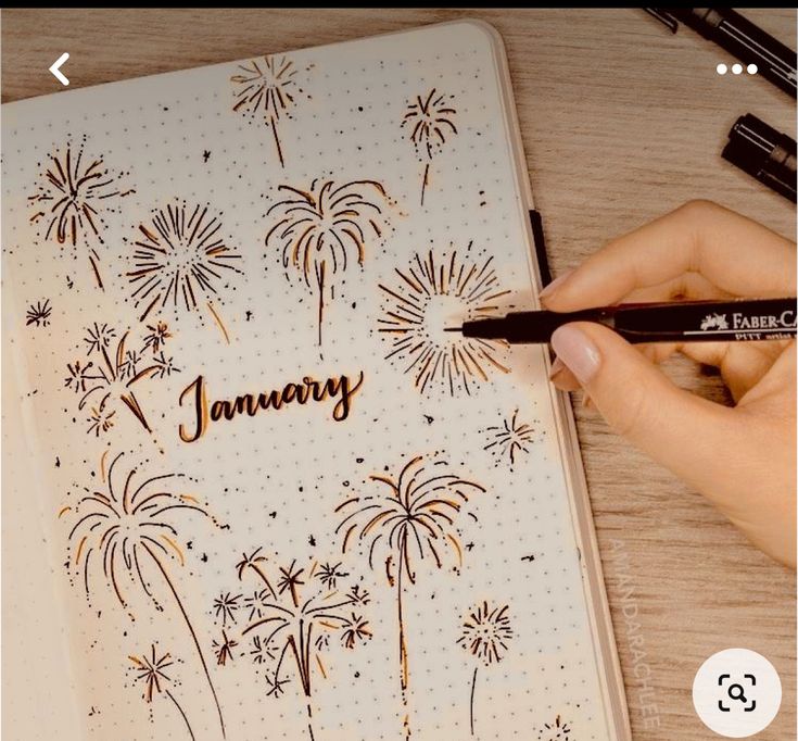 a person writing on a notebook with fireworks in the background and another hand holding a pen