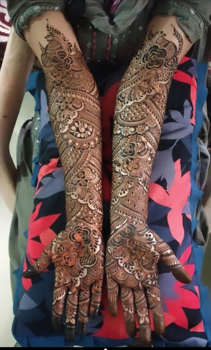 two hands with henna tattoos on them