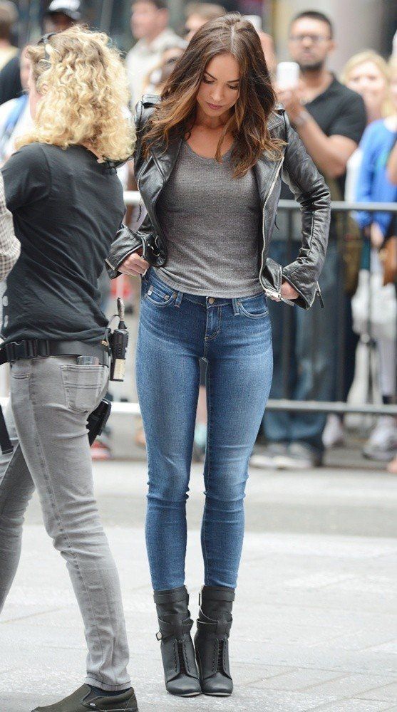 a woman is talking to another woman on the street in front of a group of people