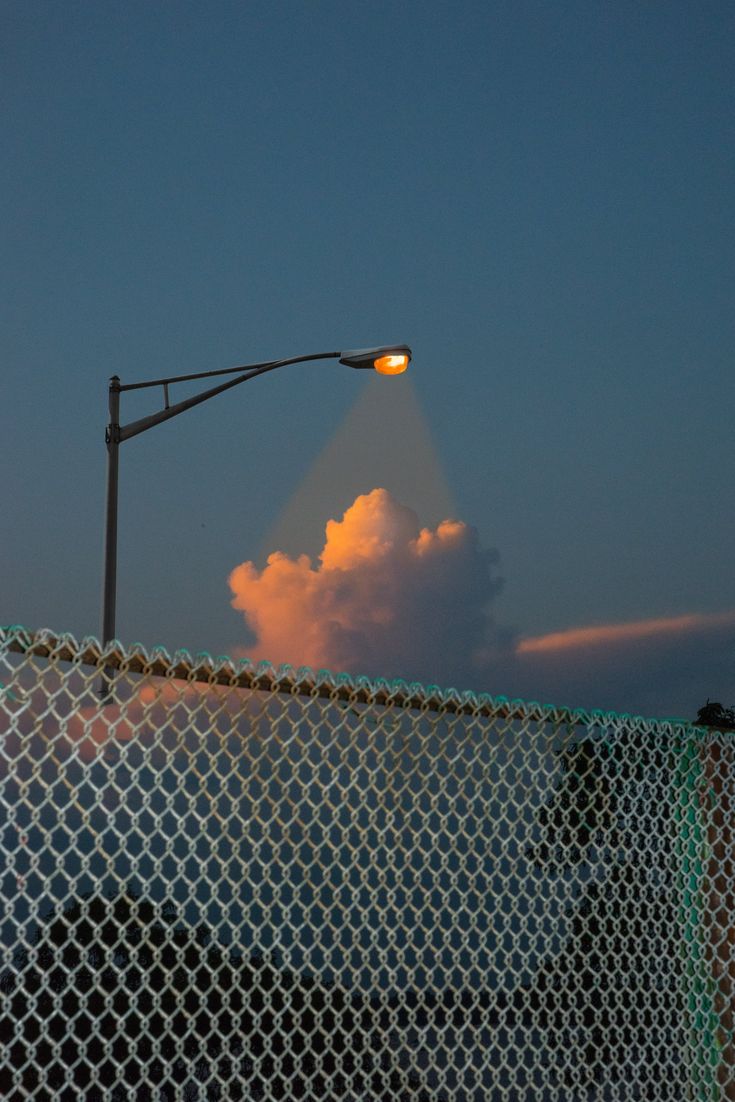 a street light on top of a chain link fence