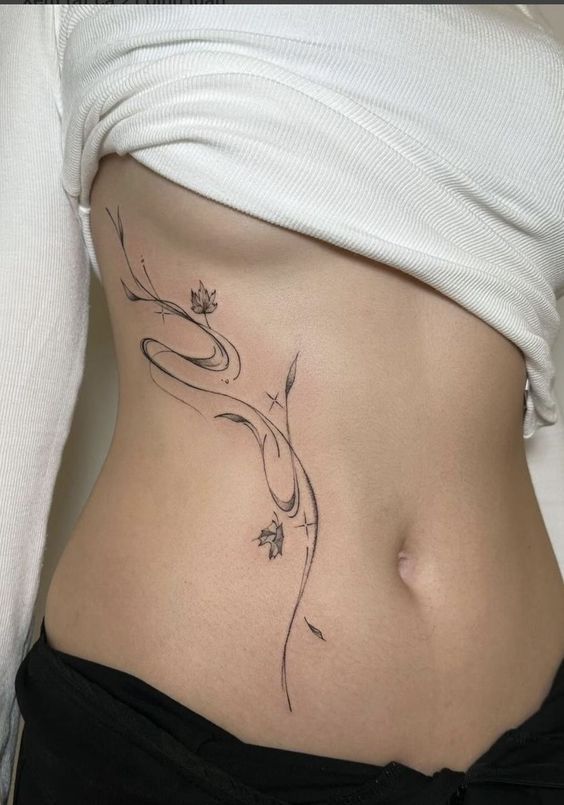 a woman's stomach with a flower tattoo on her belly and the bottom part of her abdomen