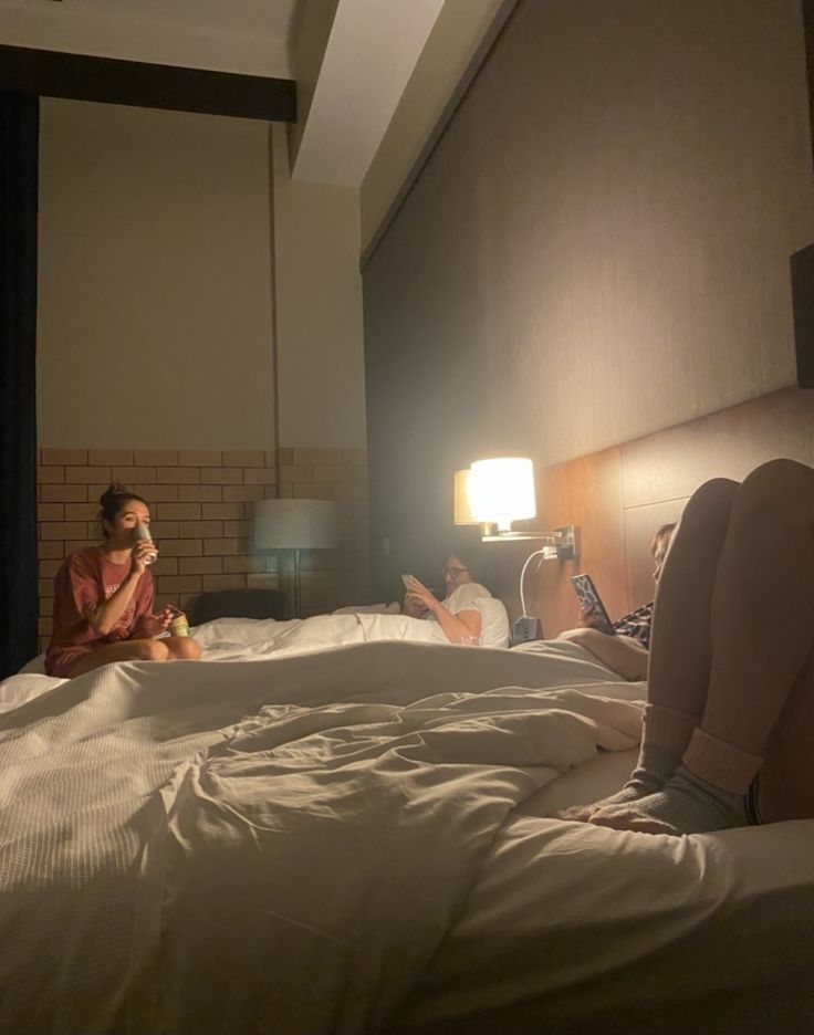 two people sitting on a bed in a hotel room