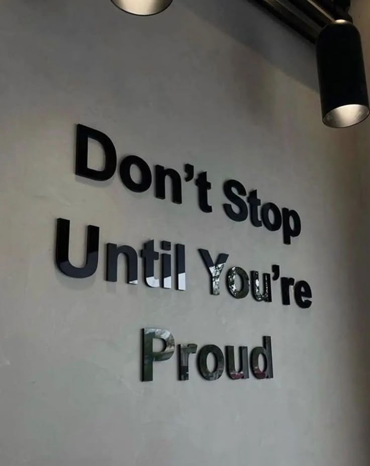 a sign that says don't stop until you're proud on the wall