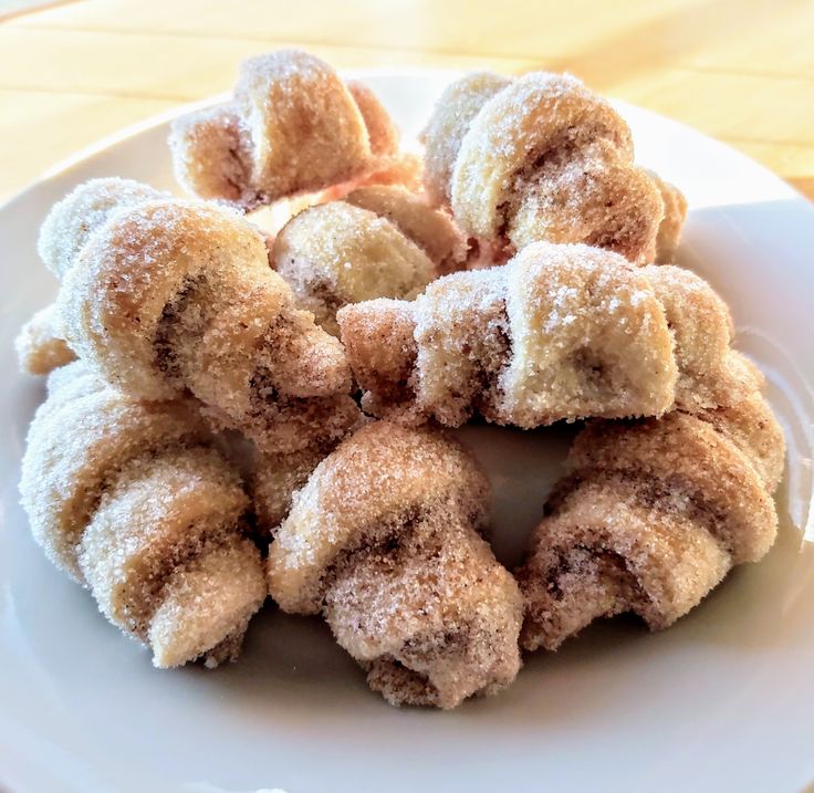 a white plate topped with sugar covered donuts