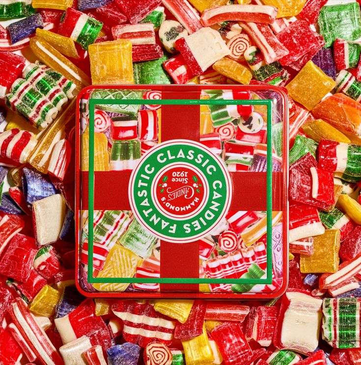 a box filled with assorted candy on top of a pile of other candies