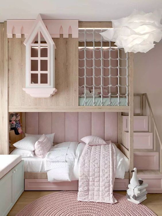 a bunk bed with a pink rug and white pillows on it, next to stairs