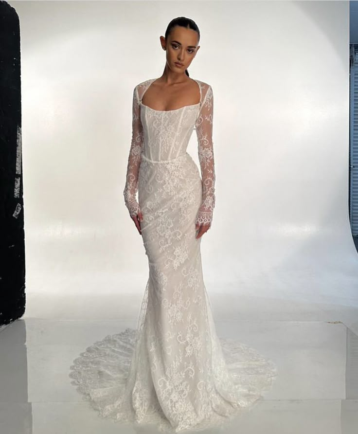 a woman in a white wedding dress is posing for the camera with her hands on her hips