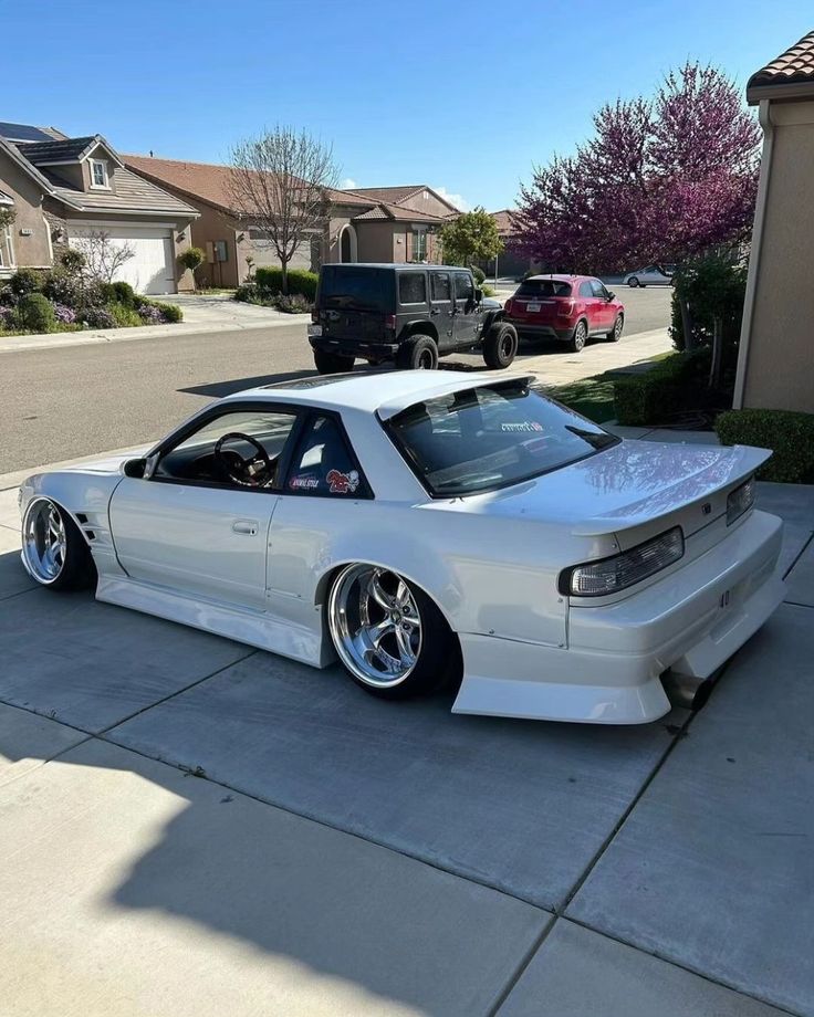 a white car parked in front of a house