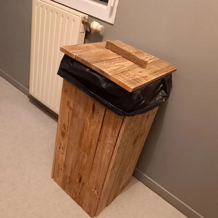 a wooden trash can sitting next to a white radiator