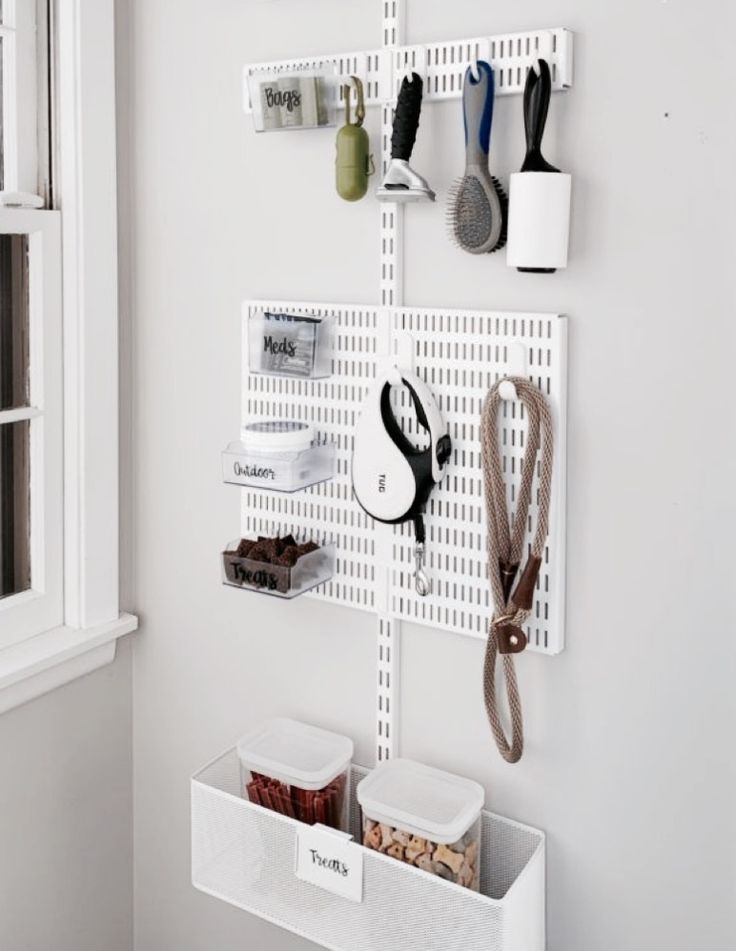 a white wall mounted shelf with scissors and other items