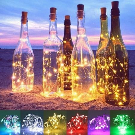 bottles with lights in them on the beach