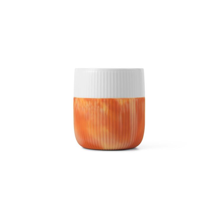 an orange and white cup sitting on top of a table