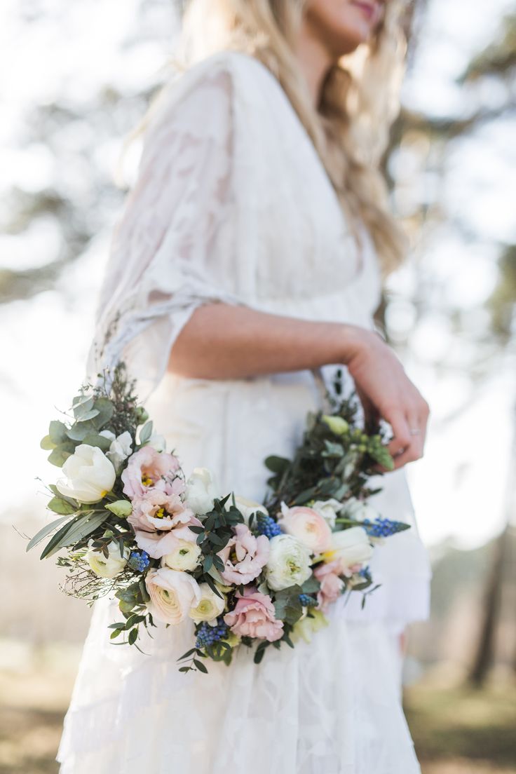 a woman in a white dress holding a bouquet of flowers