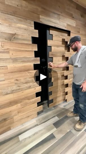 a man standing in front of a door made out of wooden planks with an opening