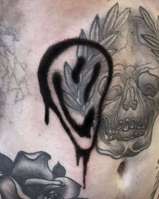 a man's chest with black ink on it and a skull in the shape of a heart