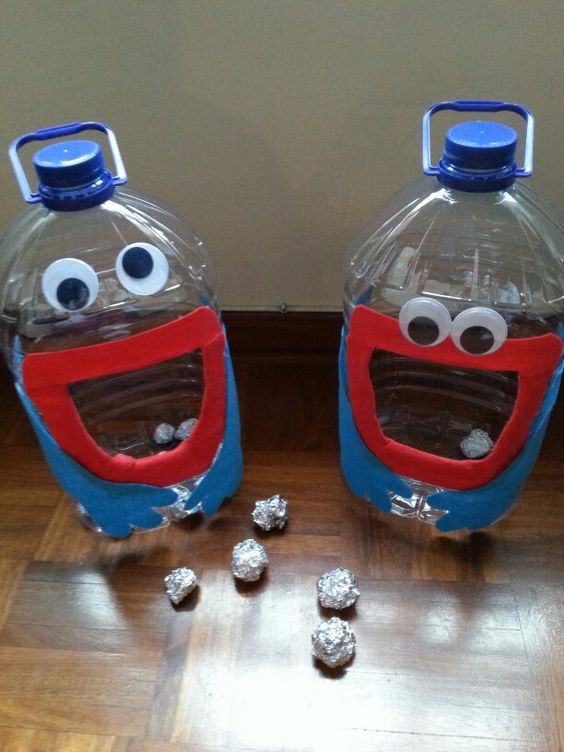 two plastic water bottles sitting on top of a hard wood floor next to some candy