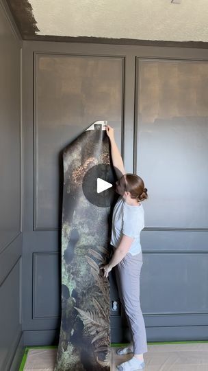 a woman standing on top of a wooden floor next to a giant board with an animal design