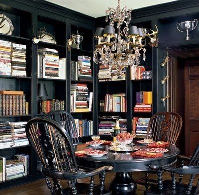 a dining room table and chairs with bookshelves in the background