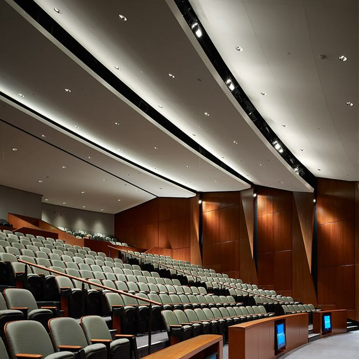 an empty auditorium with rows of seats and lights on the ceiling is seen in this image