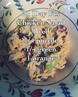 a white plate topped with chicken salad on top of a blue and white table cloth