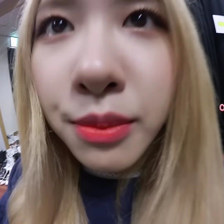 a close up of a person with long blonde hair and bright red lipstick on her lips