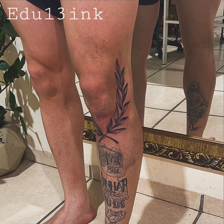 a man's legs with tattoos and writing on them in front of a mirror