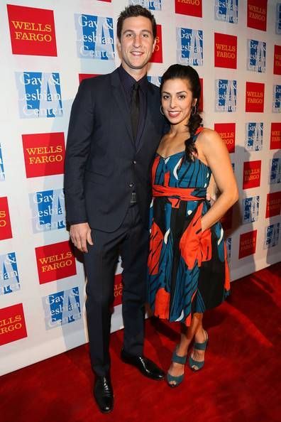 a man and woman are standing on the red carpet at a well dressed event together