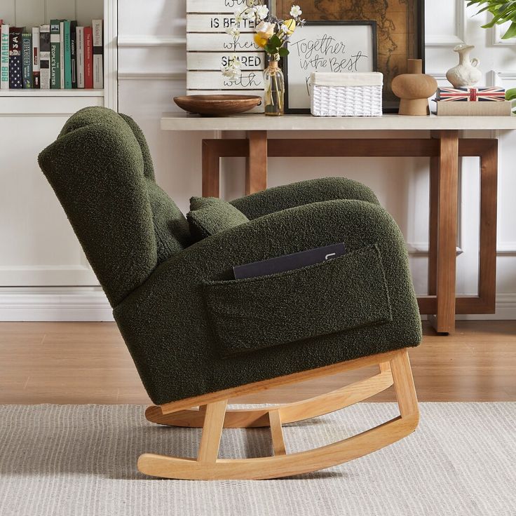 a green recliner chair sitting on top of a hard wood floor next to a table