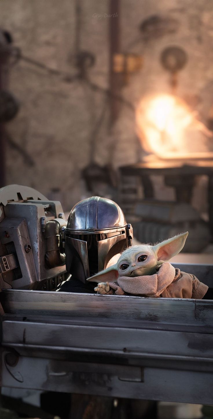 a baby yoda in the back of a truck with a star wars helmet on