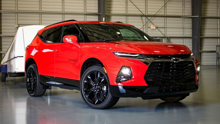 a red chevrolet suv parked in a garage