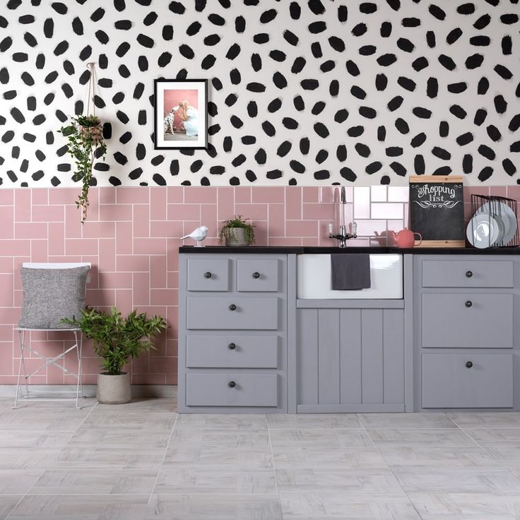 a kitchen with black and white wallpaper, pink tile flooring and grey cabinets