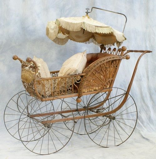 an old fashioned baby carriage with parasols on the top and bottom wheels,