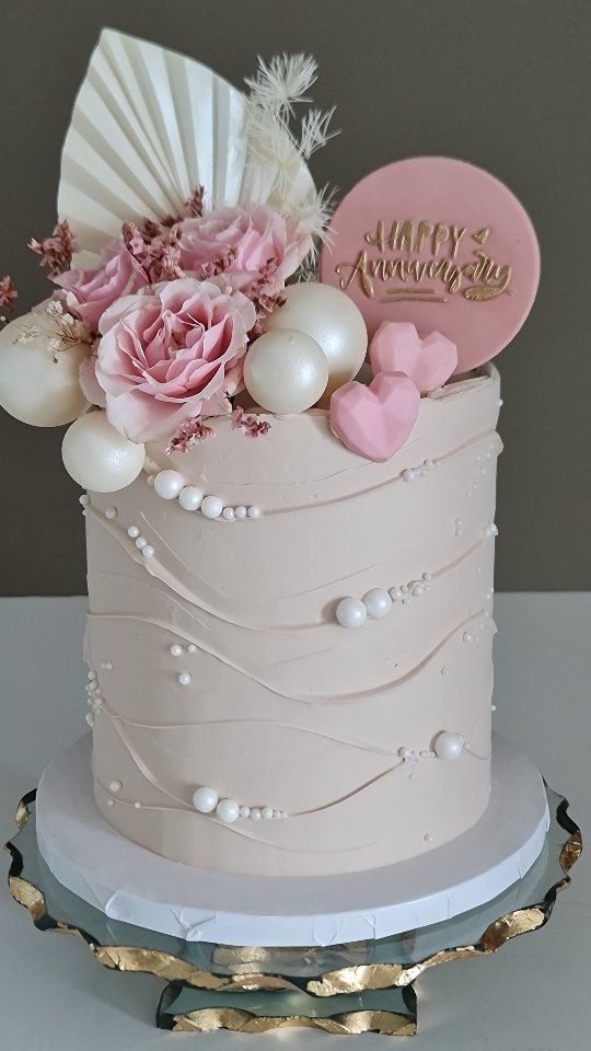 a wedding cake decorated with pink flowers and pearls