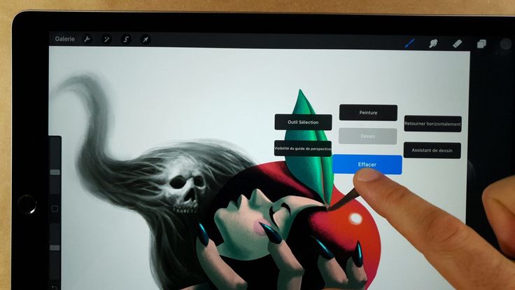 a person is pointing to an apple with a demon on it and another hand touching the screen