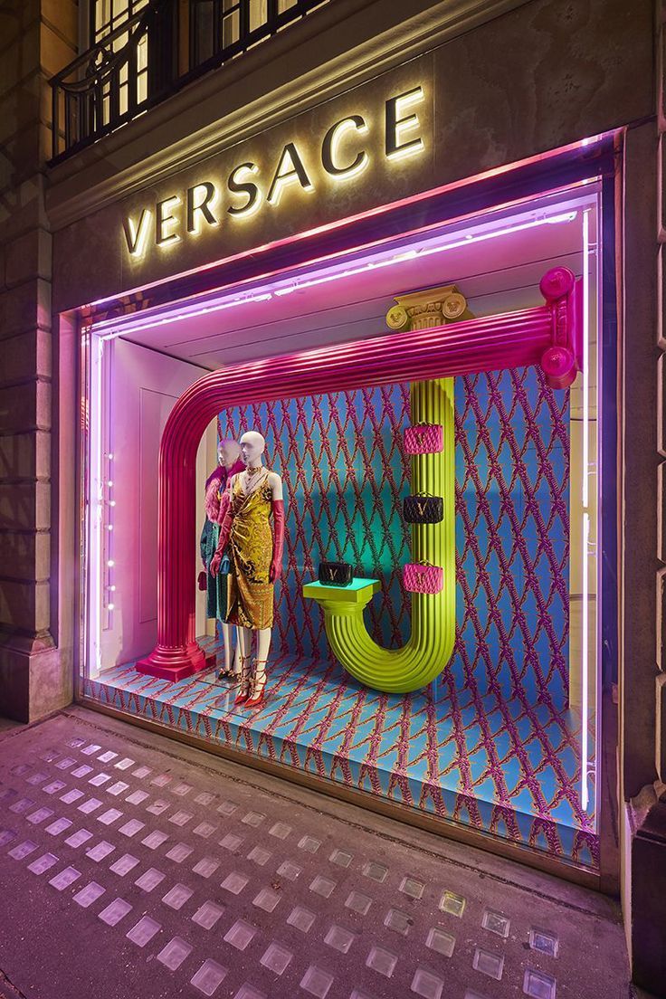 a storefront with neon lights and mannequins in the window displays an advertisement for versa