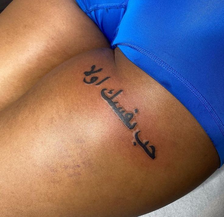 a woman's stomach with arabic writing on her lower arm and the word sulah written in cursive ink