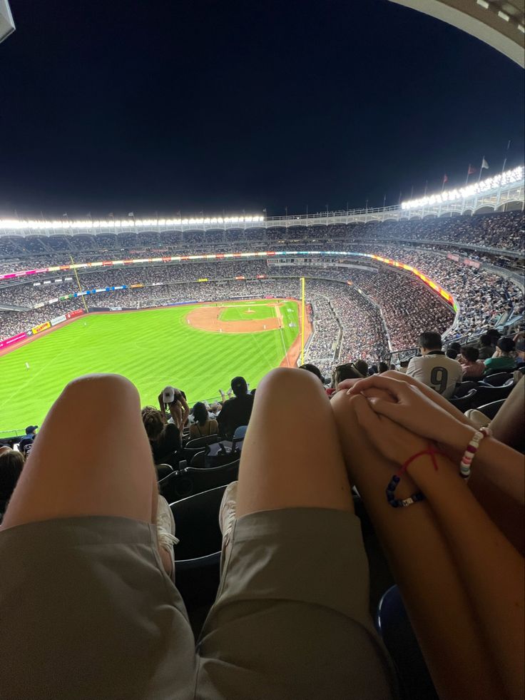 a person's legs are resting on the stands at a baseball game in an empty stadium