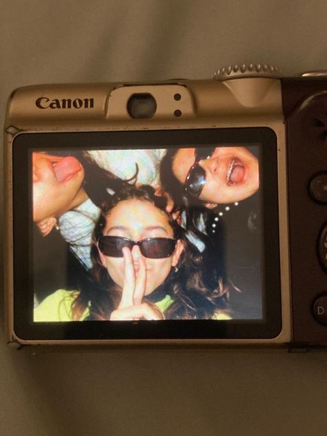 a close up of a camera with three girls on it's screen and one girl holding her hand to her face