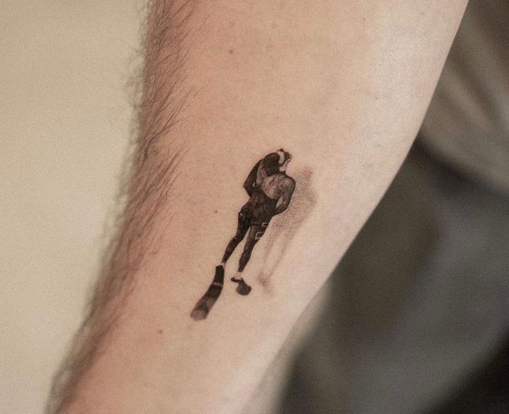 a man's arm with a small tattoo on it