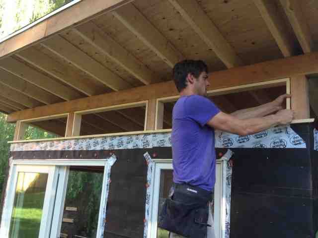 a man standing on top of a wooden roof