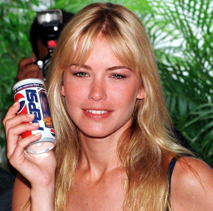 a beautiful blond woman holding a can of pepsi