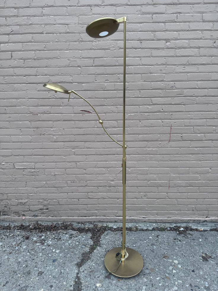 a floor lamp that is next to a brick wall